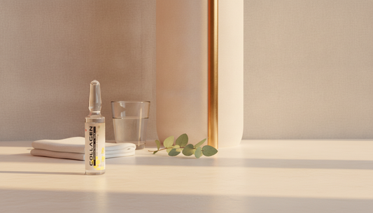Coll-Platinum collagen ampoule on a pale surface with folded cloth and eucalyptus